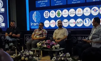 Four panel participants seated onstage before an Iran AI backdrop.
