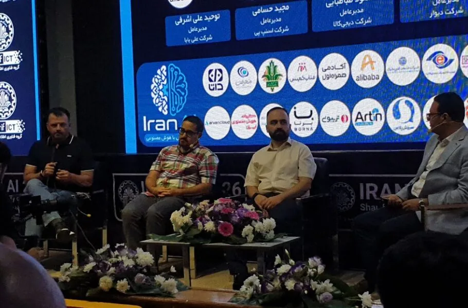 Four panel participants seated onstage before an Iran AI backdrop.