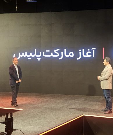 Two speakers stand on a stage at Digikala’s marketplace anniversary event.