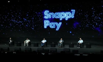 Five seated speakers take part in a panel in front of a blue SnappPay backdrop.