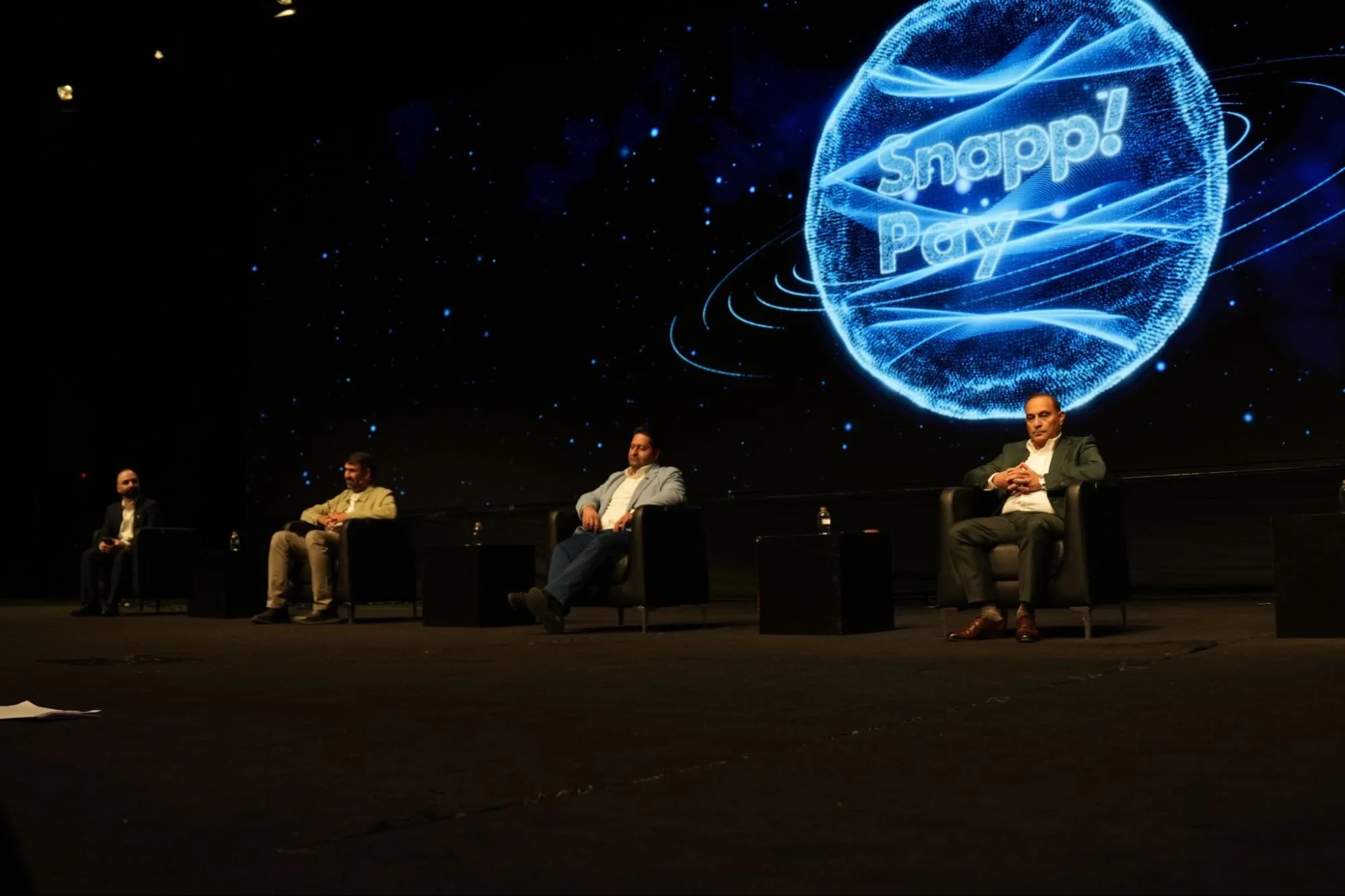 Four seated panel participants appear in front of a screen displaying the SnappPay logo.