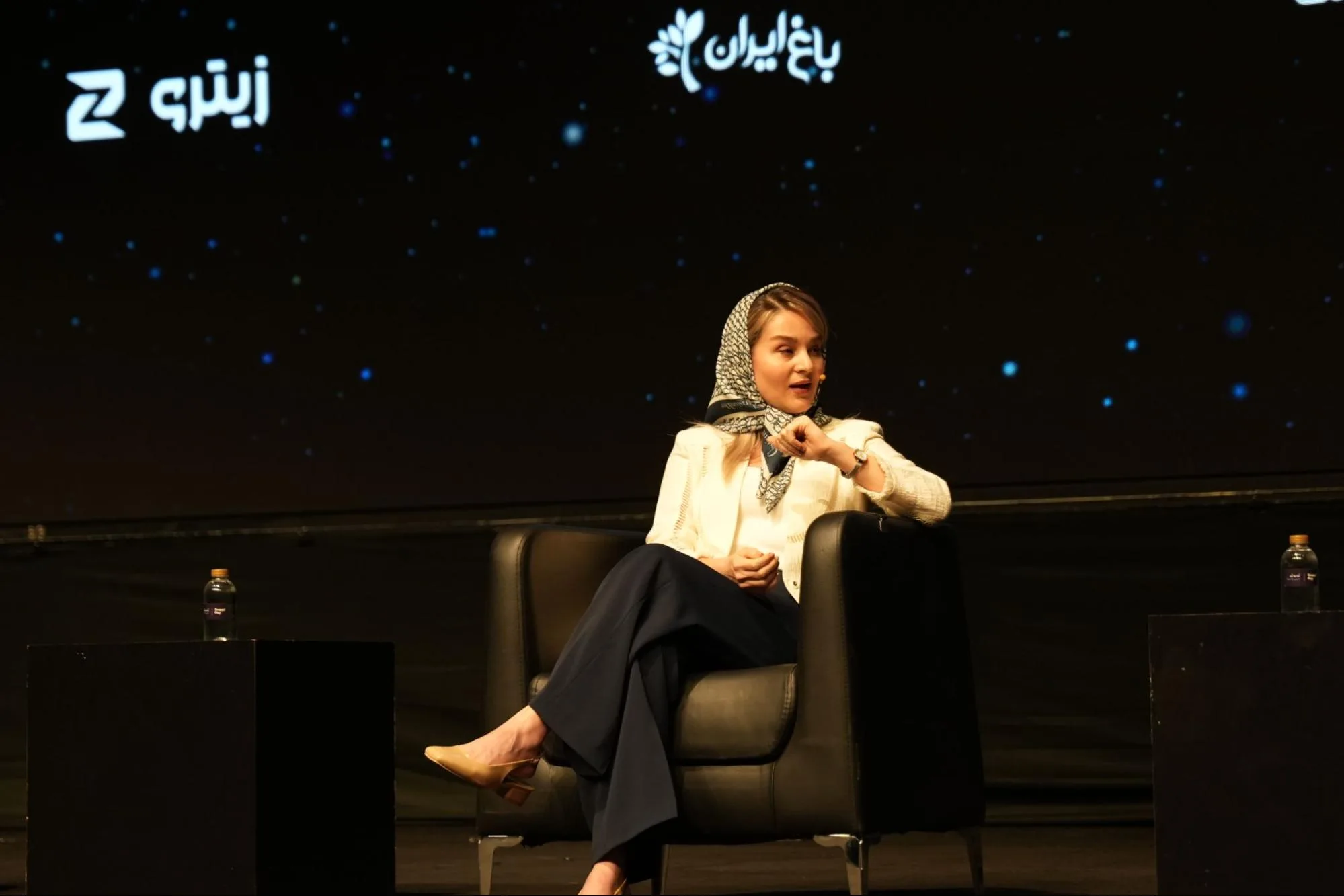 A woman holds a microphone during a panel at the SnappPay event.