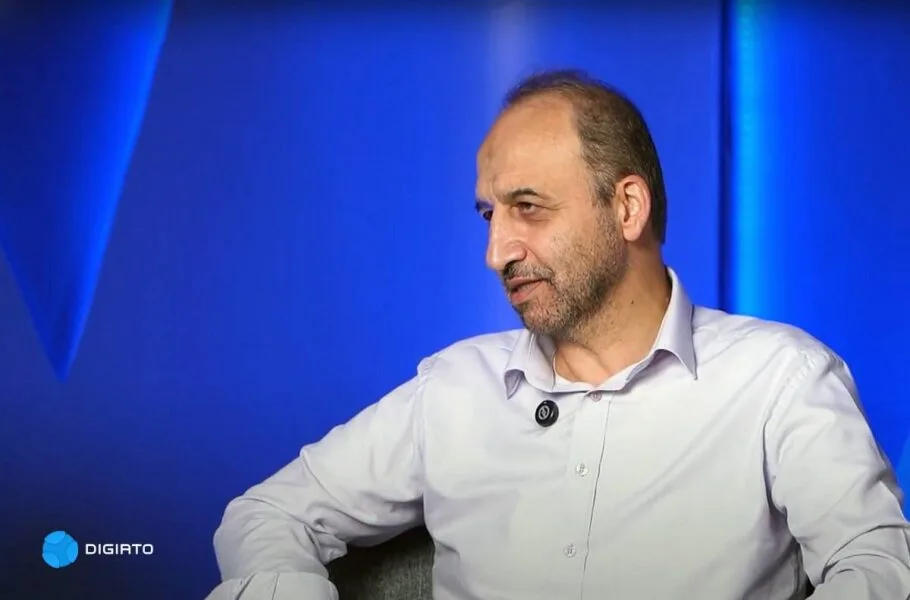 Mohammad Sarafraz seated against a blue studio backdrop.