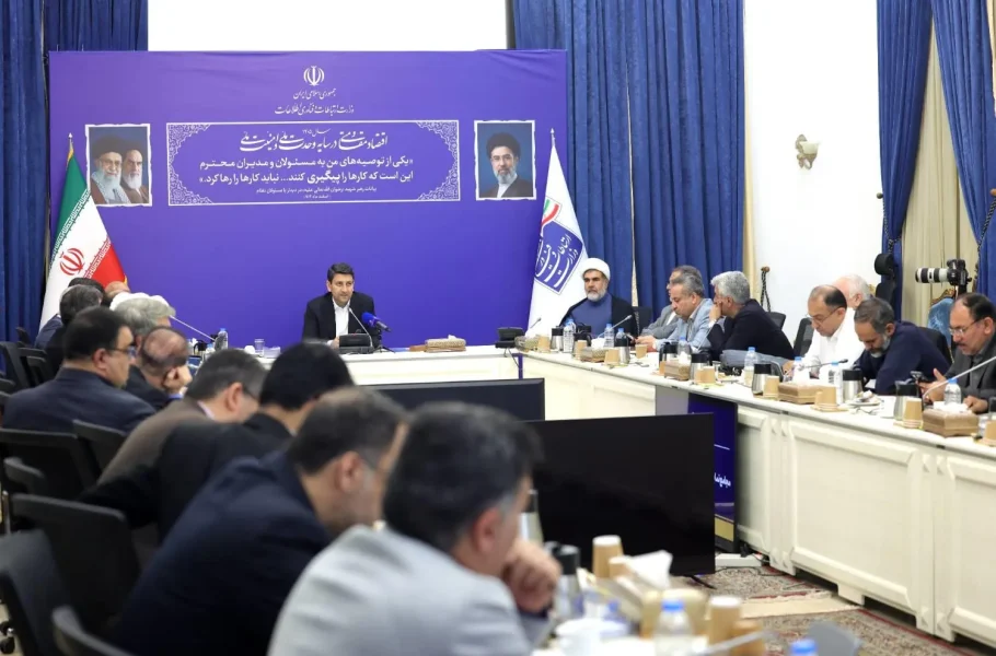 Sattar Hashemi sits at the head of a meeting table with officials seated around him.