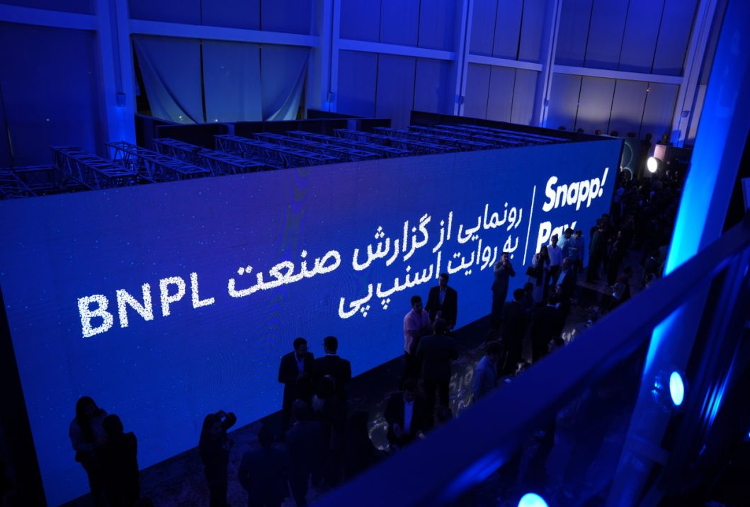 Attendees beside a blue SnappPay BNPL event backdrop.