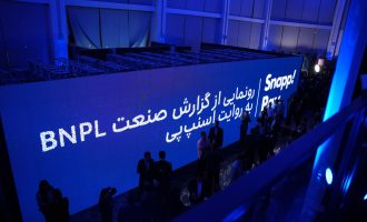 Attendees beside a blue SnappPay BNPL event backdrop.