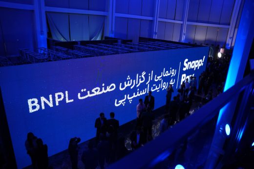 Attendees beside a blue SnappPay BNPL event backdrop.