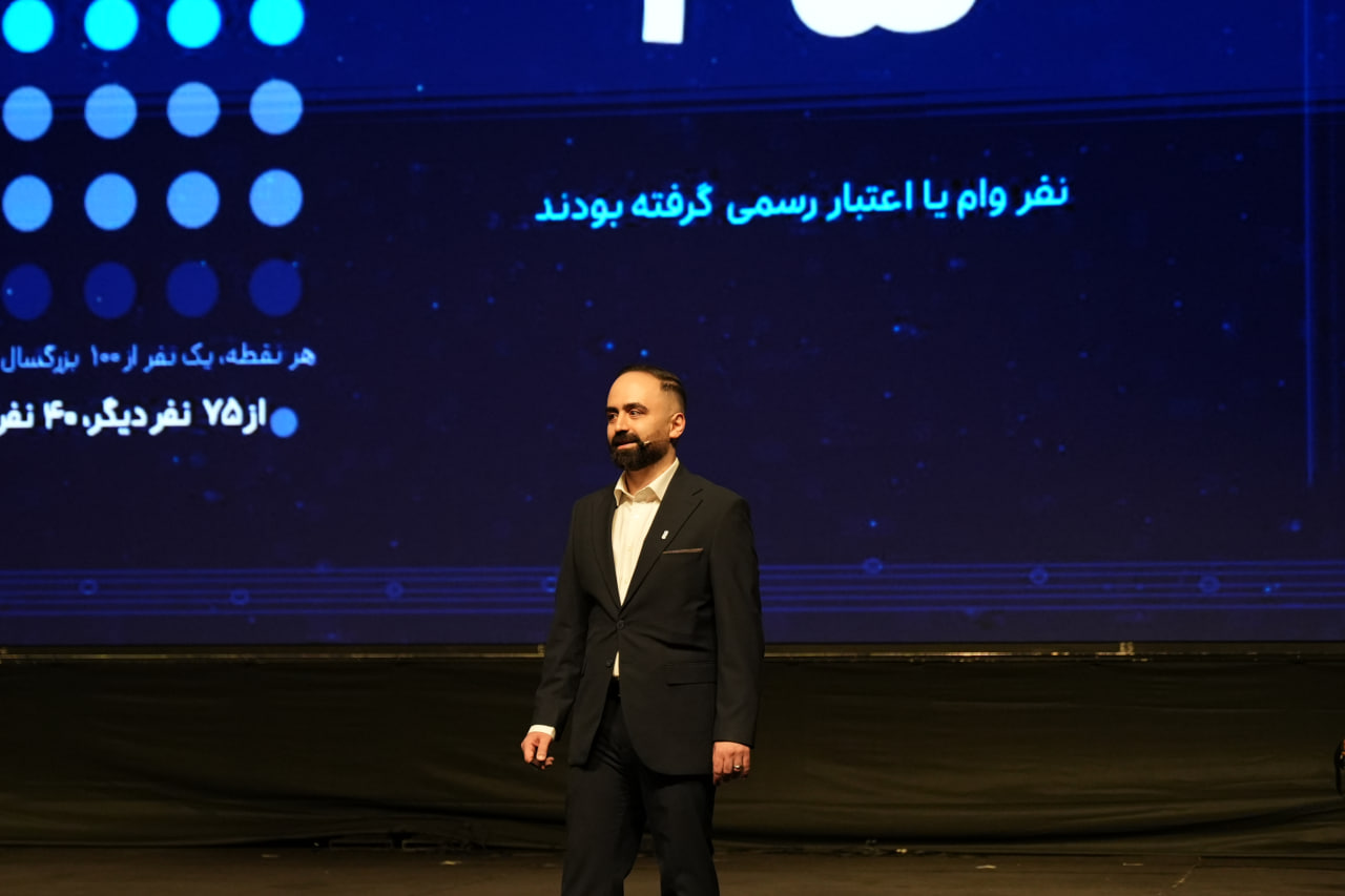 Majid Hesami onstage in front of a SnappPay presentation screen.