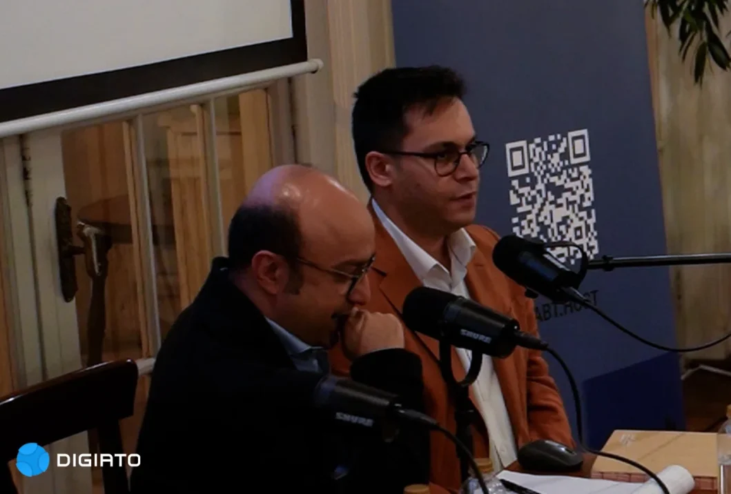 Two speakers seated at microphones beside a RabtHost banner.