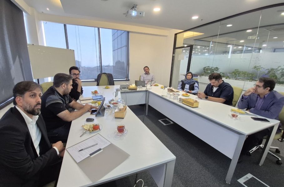 Seven people seated around a conference table in an office meeting room.